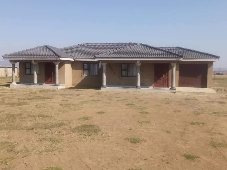 Completed tuscan-style house with red doors and tiled roof