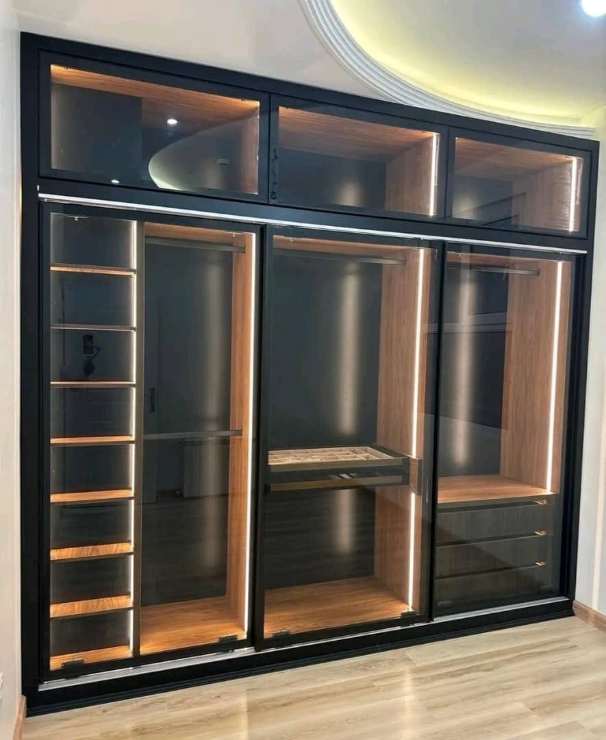 Aluminium-framed glass sliding wardrobe with internal lighting